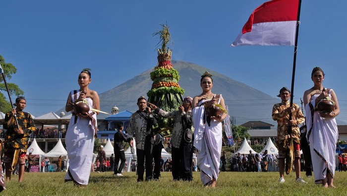 Tradisi Ruwat Rigen Tandai Mulainya Musim Panen Tembakau di Temanggung Sejumlah warga mengikuti kirab sambil mengusung gunungan saat tradisi Ruwat Rigen di lembah gunung Sindoro - Sumbing Desa Kledung, Temanggung, Jawa Tengah, Sabtu (27/7/2024). Tradisi Ruwat Rigen (tempat menjemur tembakau) sebagai pertanda dimulainya musim panen tembakau tersebut diikuti sedikitnya tiga ribu petani tembakau sebagai wujud permohonon kepada Tuhan YME agar diberi kesuksesan dan kelancaran dalam mengolah sampai menjual tembakau. ANTARA FOTO/Anis Efizudin/nz