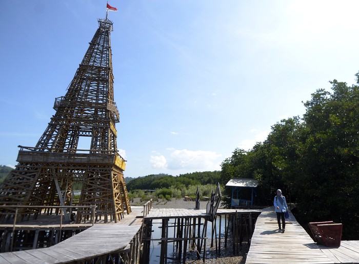 Seorang pengunjung melintasi jembatan di lokasi wisata Mangrove cuku Nyi Nyi di desa Sidodadi, Pesawaran, Lampung, Rabu (24/7/2024). Objek wisata mangrove seluas 12 hektar milik desa tersebut menjadi salah satu tujuan wisata daerah dan keberadaannya menjadi salah satu sumber penghasilan bagi desa dan UMKM sekitar. ANTARA FOTO/Ardiasnyah/nz.