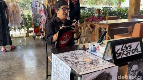Karikaturis asal Bali I Wayan Tama saat live sketch di Sanur, Denpasar, Minggu (28/7/2024). (Foto: I Nyoman Adhisthaya Sawitra/detikBali)