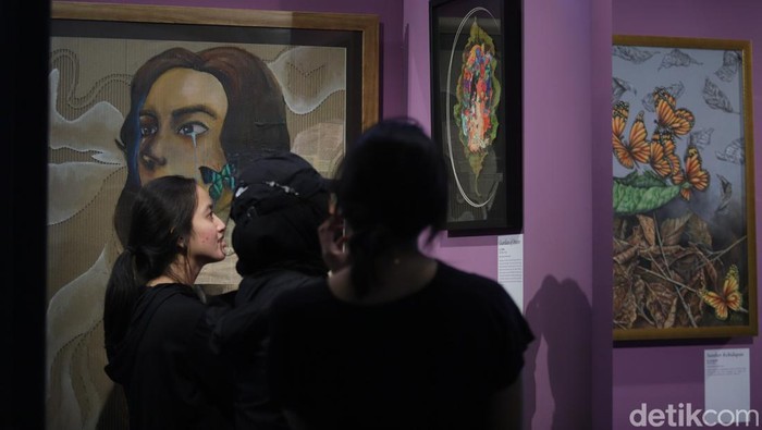 Pengunjung melihat pameran lukisan di ASHTA District 8, Minggu (28/7/2024).