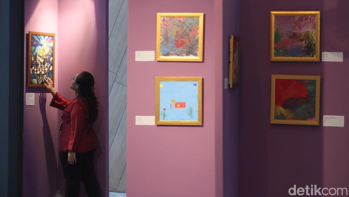 Pengunjung melihat pameran lukisan di ASHTA District 8, Minggu (28/7/2024).