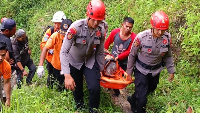 Petugas saat mengevakuasi seorang pencari perempuan rumput, Ngrangkah (56) usai terjatuh dari tebing ketinggian 5 meter di Umbulharjo, Cangkringan, Sleman, Minggu (28/7/2024).