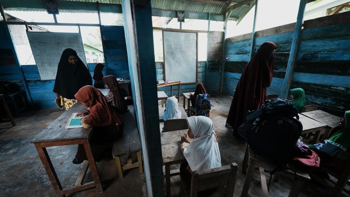 Sekolah di Suku Bajo Lapuk Dimakan Usia Dua orang guru memberi materi pelajaran ke para murid yang mayoritas suku Bajo di Madrasah Ibtidaiyah Al Ikhlas Bajoe di Desa Bajoe Indah, Konawe, Sulawesi Tenggara, Rabu (24/7/2024). Kondisi bangunan Sekolah Madrasah Ibtidaiyah yang dibangun 2012 itu sebagian telah lapuk terutama bagian atas karena dimakan usia dan dikhawatirkan berbahaya bagi murid yang menjadi juara pertama pada lomba sains madrasah tingkat kabupaten/kota di Sulawesi Tenggara di tahun 2024. ANTARA FOTO/Jojon/foc.