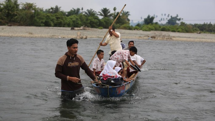 Siswa menyeberangi sungai untuk pulang dan pergi sekolah Sejumlah siswa menggunakan perahu darurat untuk melintasi sungai krueng Meureubo saat pulang sekolah dari Desa Meunuang Kinco Kecamatan Pante Ceureumen menuju Desa Cot Manggie Kecamatan Panton Reu, Aceh Barat, Aceh, Rabu (24/7/2024). Pascarusaknya jembatan gantung penghubung Kecamatan Pante Ceureumen dan Kecamatan Panton Reu akibat diterjang banjir pada November 2023 lalu, masyarakat dan siswa terpaksa melintasi sungai dengan cara berenang dan menggunakan perahu darurat untuk mempersingkat jarak tempuh karena belum adanya perbaikan jembatan oleh pihak terkait. ANTARA FOTO/Syifa Yulinnas/nz.