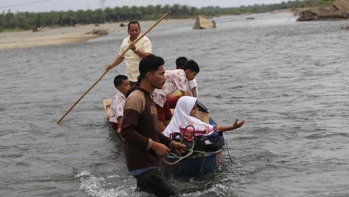 Siswa menyeberangi sungai untuk pulang dan pergi sekolah Sejumlah siswa menggunakan perahu darurat untuk melintasi sungai krueng Meureubo saat pulang sekolah dari Desa Meunuang Kinco Kecamatan Pante Ceureumen menuju Desa Cot Manggie Kecamatan Panton Reu, Aceh Barat, Aceh, Rabu (24/7/2024). Pascarusaknya jembatan gantung penghubung Kecamatan Pante Ceureumen dan Kecamatan Panton Reu akibat diterjang banjir pada November 2023 lalu, masyarakat dan siswa terpaksa melintasi sungai dengan cara berenang dan menggunakan perahu darurat untuk mempersingkat jarak tempuh karena belum adanya perbaikan jembatan oleh pihak terkait. ANTARA FOTO/Syifa Yulinnas/nz.