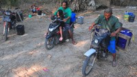 Warga mengangkut air dengan sepeda motor usai mengambil dari dari lubang atau belik yang dibuat di dasar sungai di Desa Karanganyar, Geyer, Grobogan, Jawa Tengah, Minggu (28/7/2024). 