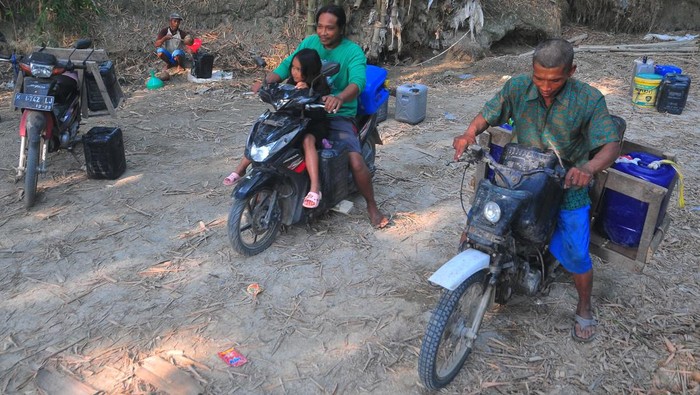 Warga mengambil air dari lubang atau belik yang dibuat di dasar sungai di Desa Karanganyar, Geyer, Grobogan, Jawa Tengah, Minggu (28/7/2024). Sejak sebulan terakhir warga di wilayah itu kesulitan air bersih akibat musim kemarau dan terpaksa mengambil air dari belik di dasar sungai yang mengering yang dimanfaatkan untuk mencuci, mandi hingga minum ternak, sementara untuk kebutuhan minum warga harus membeli air. ANTARA FOTO/Yusuf Nugroho/Spt.