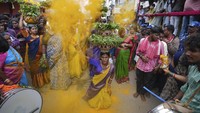 Seorang pemuja menari sambil menyeimbangkan pot-pot hias berisi nasi sebagai persembahan bagi Dewi Kali selama festival Bonalu di Hyderabad, India, Minggu (28/7/2024).