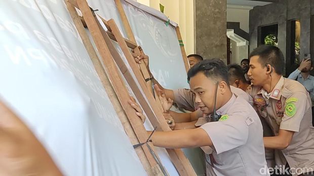 Massa berupaya menerobos masuk PN Surabaya sembari membawa karangan bunga