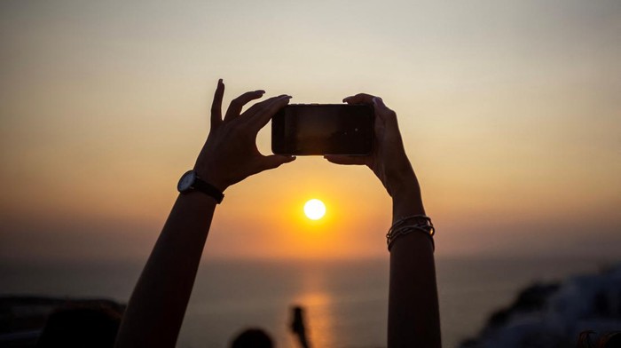 Menikmati Senja di Santorini A couple poses for a photo as tourists line up to take a photo as they view Santoriniβs famed sunset, at Santorini, Greece, July 25, 2024. REUTERS/Alkis Konstantinidis