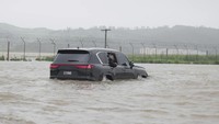 Dengan menaiki mobil, Kim nekat menerjang banjir selama tinjauannya. Tampak air sudah merendam hampir seluruh bagian ban mobilnya.  
