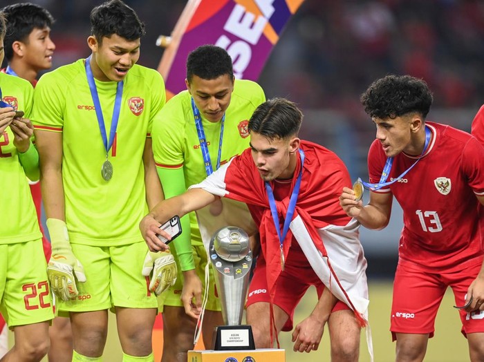 Pesepak bola Timnas Indonesia Jens Raven (kedua kanan) bersama rekan-rekannya berfoto dengan trofi Piala ASEAN U-19 Boys Championship atau AFF U-19 di Stadion Gelora Bung Tomo, Surabaya, Jawa Timur, Senin (29/7/2024). Indonesia mengalahkan Thailand dengan skor 1-0 dan menjadi juara Piala AFF U-19. ANTARA FOTO/Sigid Kurniawan/app/tom.