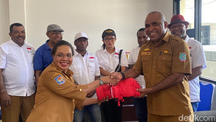 Ketua FKP3 Irian Barat 1969 Viktor Salossa menyerahkan 500 lembar bendera Merah Putih.