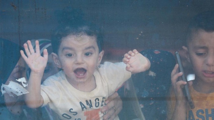 A Palestinian girl looks out of a bus window as she waits with patients to be evacuated for treatment abroad, amid Israel-Hamas conflict, in Deir Al-Balah in the central Gaza Strip July 28, 2024. REUTERS/Ramadan Abed
