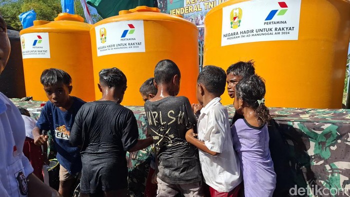 Sejumlah anak-anak di Desa Manusak, Kecamatan Kupang Timur, Kabupaten Kupang, NTT, berebutan mandi dari sumur bor yang dibangun TNI, Selasa (30/7/2024). (Yufengki Bria/detikBali).