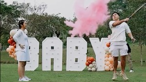 Arif Hidayat memukul sebuah bola yang kemudian mengeluarkan serbuk berwarna merah muda, menandakan anak mereka nanti adalah perempuan. Foto: Instagram/@gritteagathaa