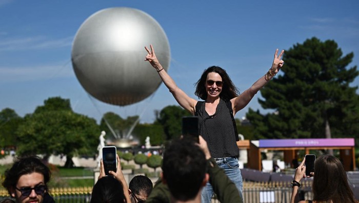 Kaldron Olimpiade Paris 2024 Jadi Spot Foto Dadakan, Begini Potretnya Paris 2024 Olympics - Paris, France - July 28, 2024 People pose for pictures in front of the Olympic cauldron during the Olympics REUTERS/Dylan Martinez