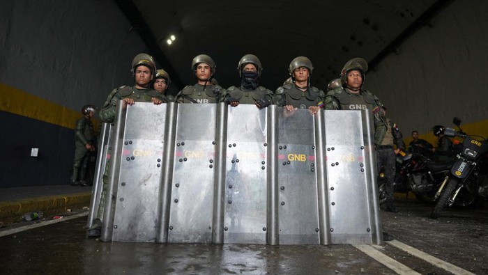 Maduro Menang Pemilu, Demo Ricuh Pecah di Venezuela Members of the Bolivarian National Guard of Venezuela stand in line after a protest from supporters of Venezuelan opposition following the announcement by the National Electoral Council that Venezuela's President Nicolas Maduro won the presidential election, in Caracas, Venezuela July 29, 2024. REUTERS/Alexandre Meneghini