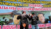 Massa juga nekat memasang banner berukuran sekitar 3x4 meter tersebut. Lalu, mereka memblokade jalan masuk utama pengunjung sidang.