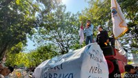 Massa membawa sejumlah banner, poster, dan keranda mayat bertuliskan Matinya Keadilan di PN Surabaya. Lalu, mereka meletakkan keranda di dekat kawat berduri yang melintang di depan PN Surabaya.