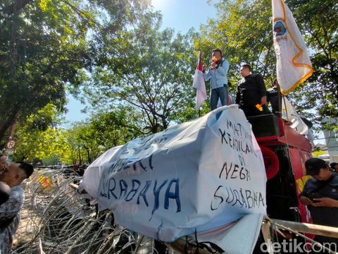 Massa menyegel PN Surabaya dengan banner saat aksi unjuk rasa kekecewaan vonis bebas Gregorius Ronald Tannur