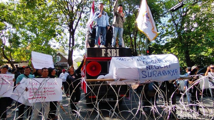 Massa menyegel PN Surabaya dengan banner saat aksi unjuk rasa kekecewaan vonis bebas Gregorius Ronald Tannur