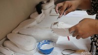 Pekerja tengah membuat cetakan sepatu pesanan pelanggan.