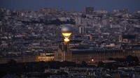 Kuali Olimpiade dinyalakan dengan api Olimpiade saat terbang di atas Paris, Prancis, saat diikatkan pada balon, seperti yang terlihat dari Menara Eiffel. AP/Geoffroy Van Der Hasselt