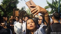 Warga berswafoto dengan latar belakang Gibran Rakabuming.