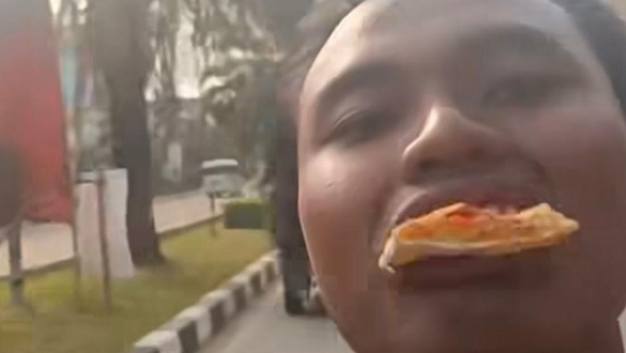 Viral pria Depok makan pizza sambil motoran, nyetir pakai kaki.
