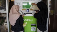 Warga memasukan minyak jelantah pada mesin setor minyak jelantah menjadi rupiah Ucollect di Saung Bambu Cibadak, Bandung, Jawa Barat, Selasa (30/7/2024).   