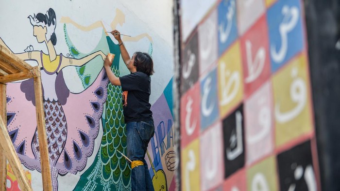 Mahasiswa melukis mural di Gang Cikapundung, Braga, Bandung, Jawa Barat, Selasa (30/7/2024). Mahasiswa dan dosen jurusan DKV Universitas Pasundan menghias Gang Cikapundung di Kawasan Wisata Braga dengan mural yang bertemakan kebudayaan dan sejarah guna memberikan daya tarik baru yang diharapkan mampu meningkatkan kunjungan wisata ke kawasan tersebut. ANTARA FOTO/Raisan Al Farisi/aww.