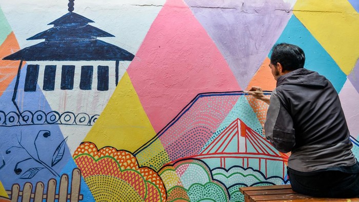 Mahasiswa melukis mural di Gang Cikapundung, Braga, Bandung, Jawa Barat, Selasa (30/7/2024). Mahasiswa dan dosen jurusan DKV Universitas Pasundan menghias Gang Cikapundung di Kawasan Wisata Braga dengan mural yang bertemakan kebudayaan dan sejarah guna memberikan daya tarik baru yang diharapkan mampu meningkatkan kunjungan wisata ke kawasan tersebut. ANTARA FOTO/Raisan Al Farisi/aww.