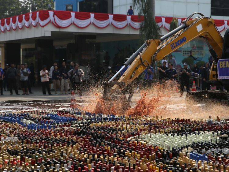 Aksi Eskavator Musnahkan Ribuan Botol Miras Ilegal