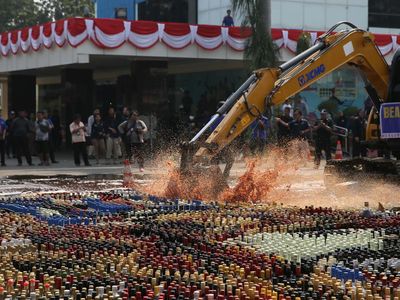 Aksi Eskavator Musnahkan Ribuan Botol Miras Ilegal