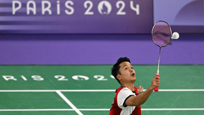 Indonesias Anthony Sinisuka Ginting hits a shot to US Howard Shu in the mens singles badminton group stage match during the Paris 2024 Olympic Games at Porte de la Chapelle Arena in Paris on July 28, 2024. (Photo by Arun SANKAR / AFP)
