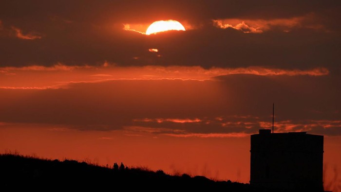 A person walks near Madliena Tower at sunset in Pembroke, Malta, July 30, 2024. REUTERS/Darrin Zammit Lupi