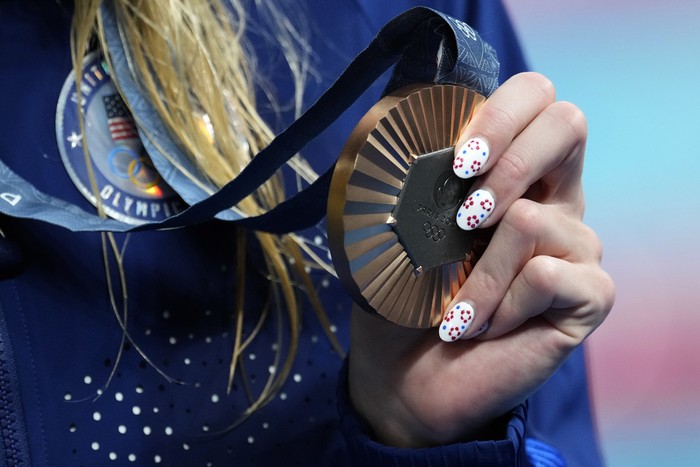 Bronze medalist Katharine Berkoff, of the United States, shows off her medal following the womens 100-meter backstroke final at the 2024 Summer Olympics, Tuesday, July 30, 2024, in Nanterre, France.(AP Photo/Ashley Landis)