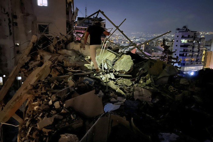 Civil defence workers check for victims between the wreckage of destroyed buildings that were hit by an Israeli airstrike in the southern suburbs of Beirut, Lebanon, Tuesday, July 30, 2024. An Israeli airstrike hit Hezbollahs stronghold south of Beirut Tuesday evening causing damage, a Hezbollah official and the groups TV station said. (AP Photo/Hussein Malla)