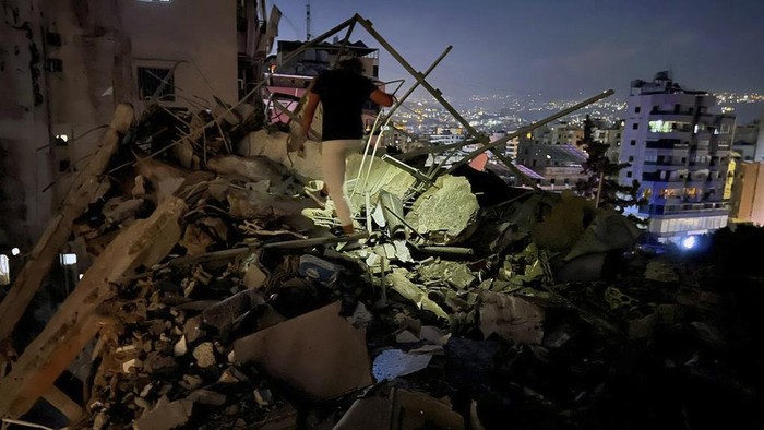 Potret Kehancuran di Kota Beirut Ulah Rudal Israel Civil defence workers check for victims between the wreckage of destroyed buildings that were hit by an Israeli airstrike in the southern suburbs of Beirut, Lebanon, Tuesday, July 30, 2024. An Israeli airstrike hit Hezbollah's stronghold south of Beirut Tuesday evening causing damage, a Hezbollah official and the group's TV station said. (AP Photo/Hussein Malla)