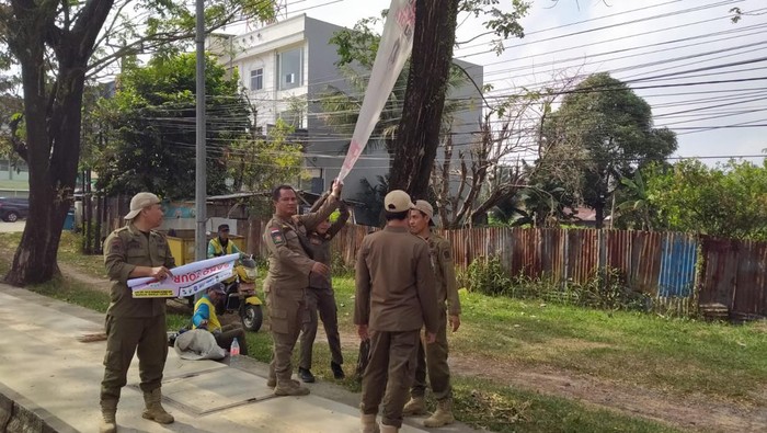 Satpol PP Palembang turunkan APK bacawako yang melanggar aturan.
