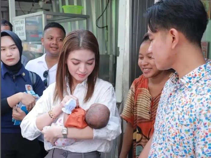 Selvi Ananda saat menggendong bayi ketika ikut mendampingi Gibran Rakabuming blusukan di Tangerang (Foto: Instagram @selvie_ananda_)