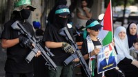 Anak-anak mengibarkan bendera Palestina, memegang foto Ismail Haniyeh, dan mengangkat senjata mainan.