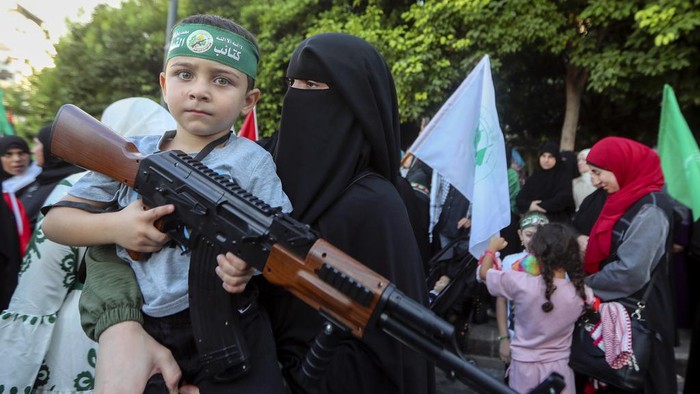 Anak-anak Lebanon Angkat 'Senjata' Setelah Kematian Pemimpin Hamas Supporters of the Islamist Hamas movement hold posters of Hamas political chief Ismail Haniyeh during a protest to condemn his killing, at the Palestinian refugee camp of Ein el-Hilweh near the southern port city of Sidon, Lebanon, Wednesday, July 31, 2024. Haniyeh, Hamas' political chief in exile who landed on Israel's hit list after the militant group staged its surprise Oct. 7 attacks, was killed in an airstrike in the Iranian capital early Wednesday. (AP Photo/Mohammed Zaatari)