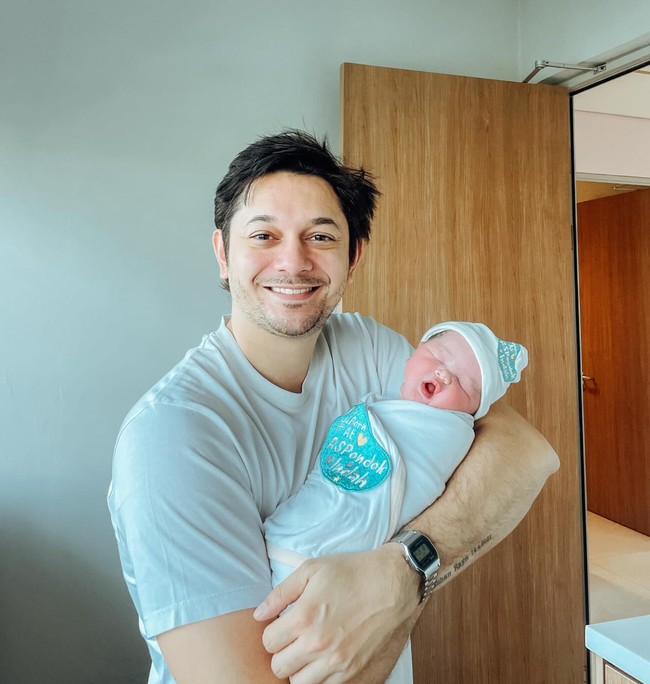 Setelah putrinya lahir, Andrew langsung menggendong dan berpose bersama anak keduanya dengan Tengku Dewi tersebut. Ekspresi bahagia pun jelas terpancar dari wajahnya. Foto: Instagram/@andrewandika