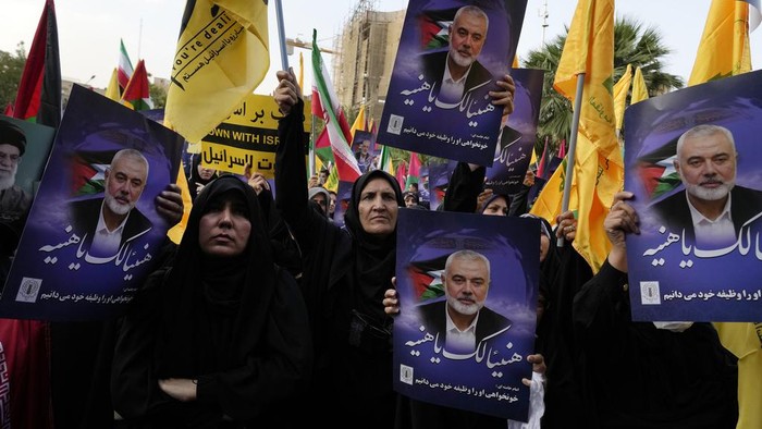 Iranian workers install a huge banner on a wall showing a portrait of Hamas leader Ismail Haniyeh and the Dome of Rock Mosque at the Al-Aqsa Mosque compound of Jerusalem at Felestin (Palestine) Sq. in Tehran, Iran, Wednesday, July 31, 2024. Haniyeh was assassinated in Tehran, Irans paramilitary Revolutionary Guard said early Wednesday. (AP Photo/Vahid Salemi)