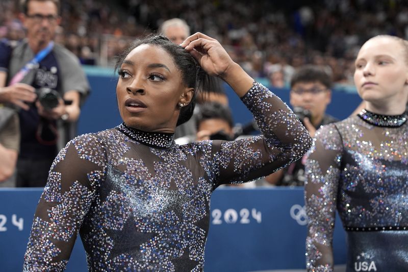 Gaya Rambut Simone Biles di Olimpiade 2024 Simone Biles, of the United States, waits to compete in the women's artistic gymnastics team finals round at Bercy Arena at the 2024 Summer Olympics, Tuesday, July 30, 2024, in Paris, France. (AP Photo/Charlie Riedel)