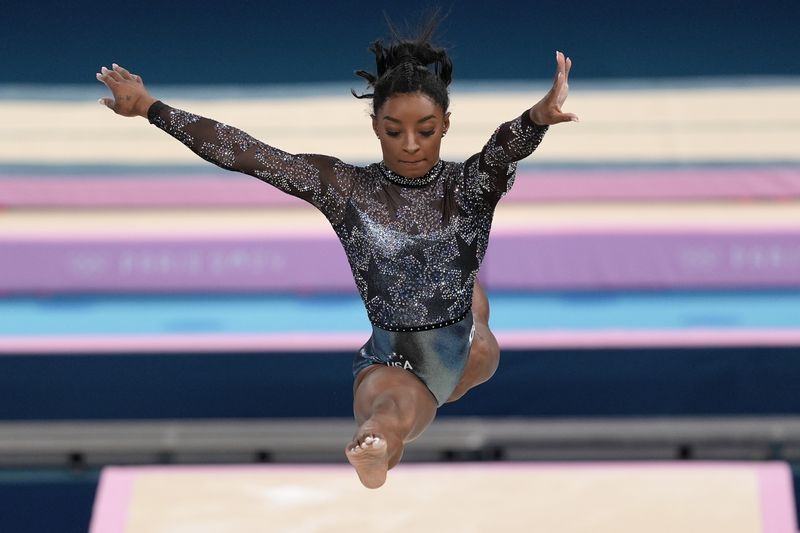 Gaya Rambut Simone Biles di Olimpiade 2024 Simone Biles, of United States, competes on the balance beam during a women's artistic gymnastics qualification round at the 2024 Summer Olympics, Sunday, July 28, 2024, in Paris, France. (AP Photo/Francisco Seco)