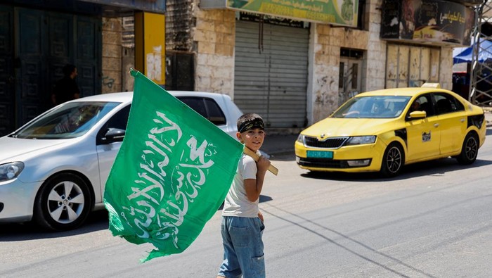Ismail Haniyeh Dibunuh, Tepi Barat Bergolak A Palestinian boy holds a flag while attending a protest after the assassination of Hamas leader Ismail Haniyeh in Iran, in Tubas in the Israeli-occupied West Bank July 31, 2024. REUTERS/Raneen Sawafta