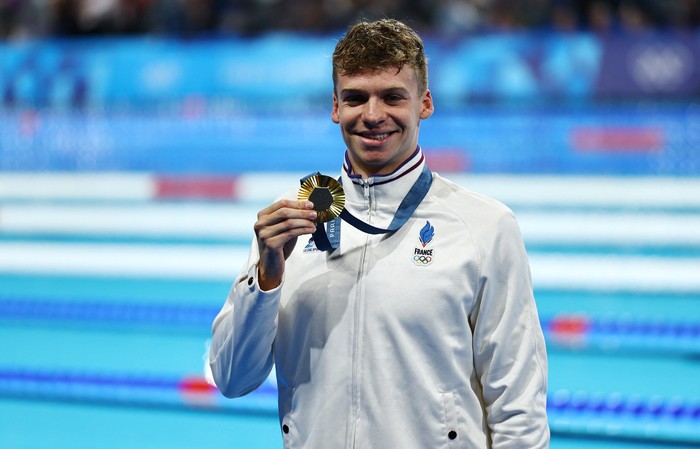 Paris 2024 Olympics - Swimming - Mens 200m Breaststroke Victory Ceremony - Paris La Defense Arena, Nanterre, France - July 31, 2024.  Gold medallist Leon Marchand of France celebrates after winning the race and setting a new Olympic record. REUTERS/Ueslei Marcelino